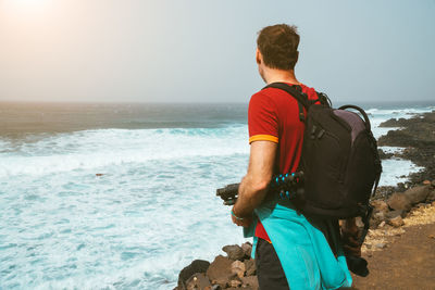 Rear view of man on beach against sky