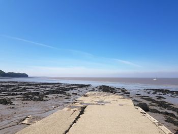 Scenic view of beach against blue sky