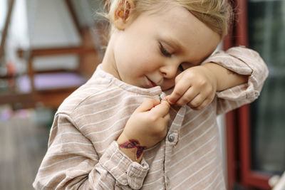 Close up of little boy who buttons his shirt