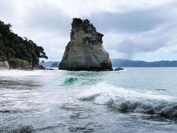 Rock formation in sea against sky