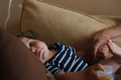 Portrait of baby boy lying on sofa at home