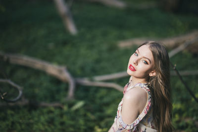 Portrait of smiling young woman sitting in park