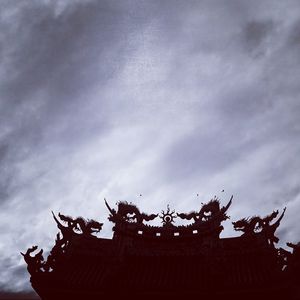 Low angle view of silhouette sculpture against sky