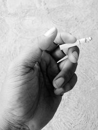 Close-up of cropped hand holding cigarette