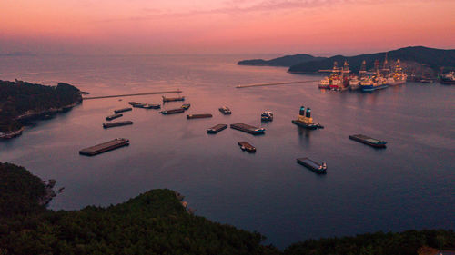 Boats moored on sea against sky during sunset