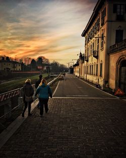 Rear view of people walking on road in city