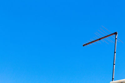 Low angle view of windmill against clear blue sky