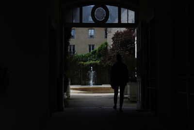 Rear view of man walking on building at night