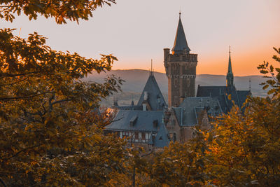 Trees and buildings against sky during autumn