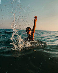 Woman swimming in sea against sky