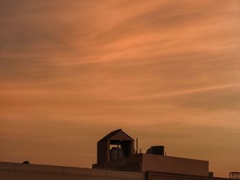 Low angle view of building against orange sky