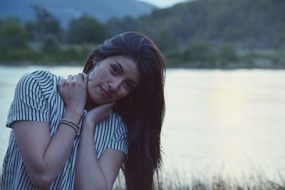 Portrait of young woman against lake