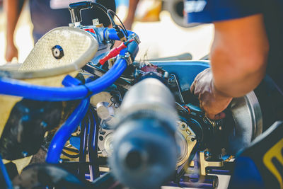 Cropped hand of mechanic repairing go-cart