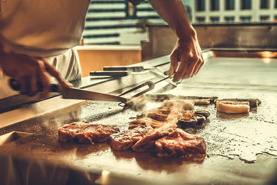 Midsection of person preparing food on table in kitchen