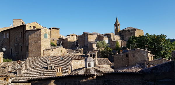 Buildings in city against clear blue sky