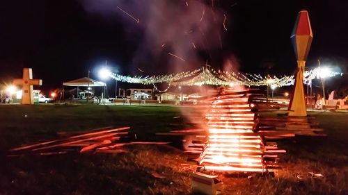 Light trails on illuminated city against sky at night