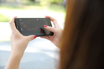 Cropped hands of woman using mobile phone