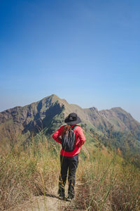 Rear view of man on mountain against sky