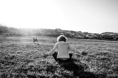 Rear view of man standing on grassy field