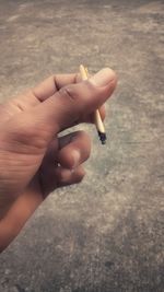 Close-up of hand holding cigarette