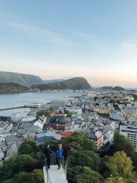 High angle view of townscape by sea against sky