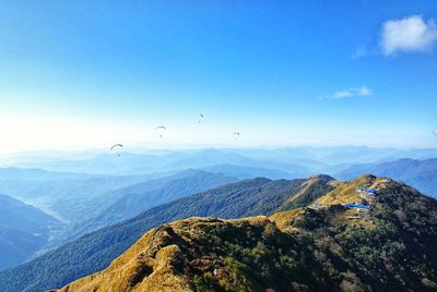 Scenic view of mountains against blue sky during sunny day