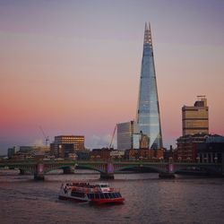 Shard london bridge by thames river against sky during sunset in city