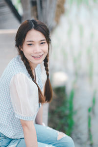 Portrait of young woman sitting on field