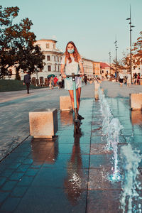 Young woman riding an electric scooter in the city center. woman wearing the face mask