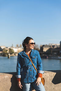 Young woman standing in water against clear sky