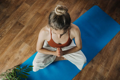 Rear view of woman sitting on hardwood floor