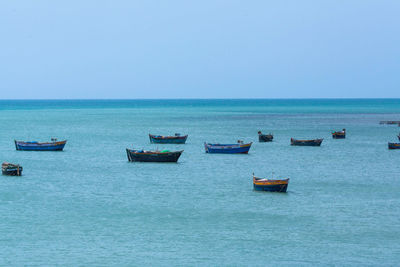 View of boats in sea against clear sky