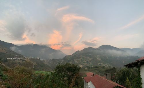 Scenic view of mountains and houses against sky