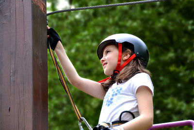 Adventure climbing high wire park - people on course in mountain helmet and safety equipment.