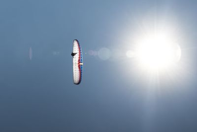 Low angle view of person paragliding against sky