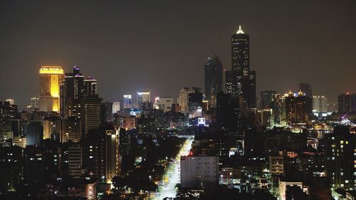 Illuminated buildings in city against sky at night