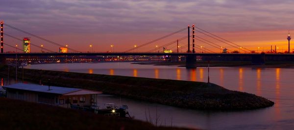 View of suspension bridge in city at sunset