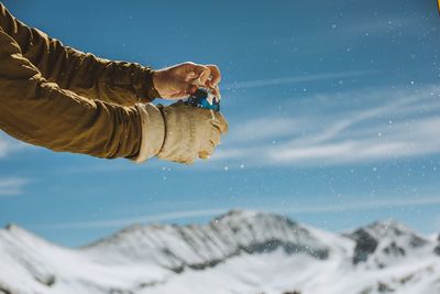 Low section of person on snow against sky