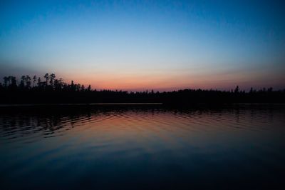 Scenic shot of calm lake at sunset