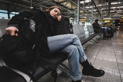 Young woman sleeping at airport waiting lounge