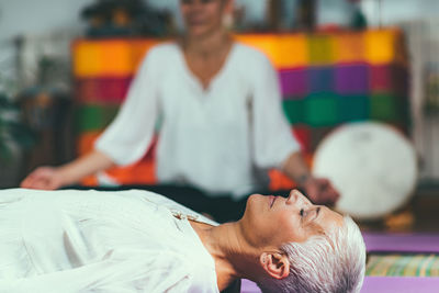 Midsection of women meditating in spa