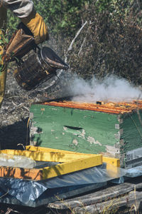 Midsection of beekeeper working at farm