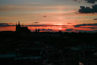 Silhouette buildings in city against sky at sunset