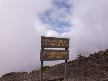 Information sign on road against sky