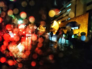 People walking on illuminated street at night
