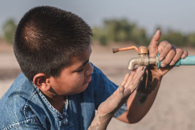 Boy looking at empty faucet