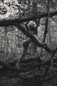 Blonde bare lady climbing on dry branches monochrome scenic photography