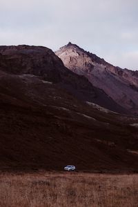 Scenic view of land and mountains against sky