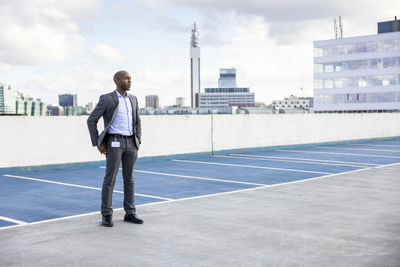 Full length rear view of man standing against sky in city