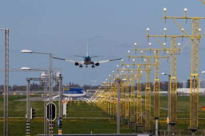 Airplane landing on runway against blue sky